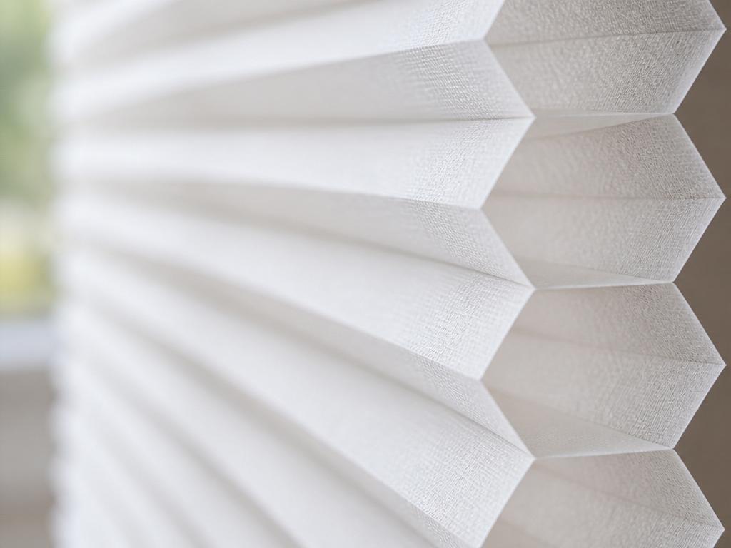 Double-cell honeycomb shades stacked slimly at the top of a tall window