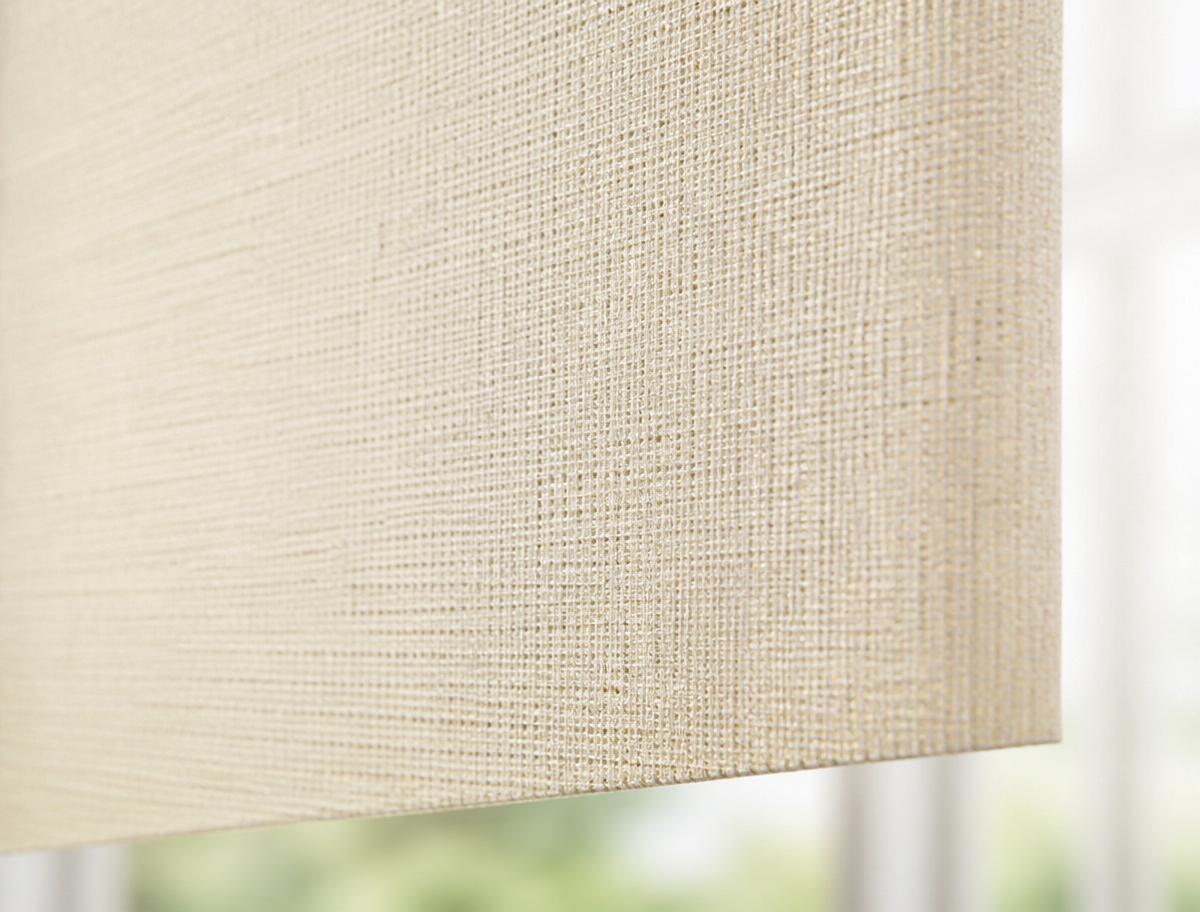 Dual roller shades layering light-filtering and blackout fabrics in a living room